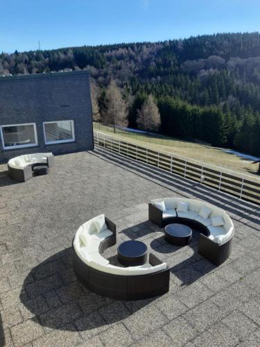 a patio with a circularvisor with two benches on a building at Landhaus Schlossberg in Medebach