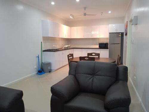 sala de estar con sofá y cocina en Prestige Apartments - Solomon Islands, en Honiara