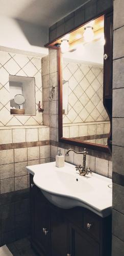 a bathroom with a white sink and a mirror at Tsagarada Stone House 1898 in Tsagarada