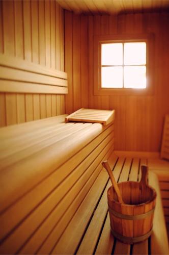 a sauna with a tub and a bucket in it at Pippo Hotel in Terzolas