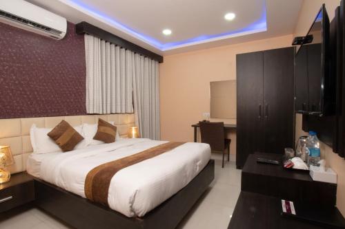 a hotel room with a bed and a desk at Annapurna Hotel in Bīrganj