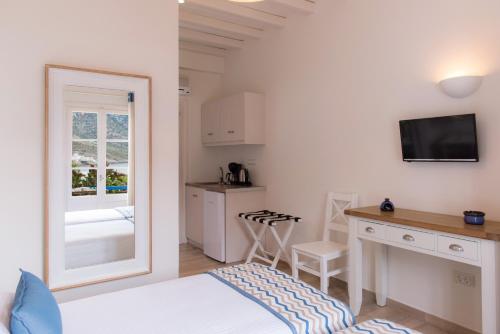 a bedroom with a bed and a desk and a mirror at Boufounis Studios in Kamarai