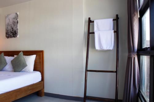 a bedroom with a bed and a towel rack at 3 Laan House in Chiang Mai