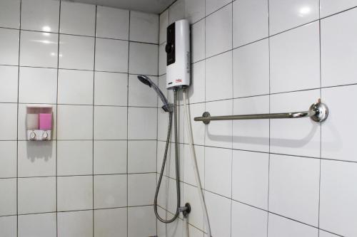 a shower with a phone on a tiled wall at 3 Laan House in Chiang Mai