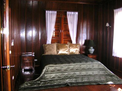 a bedroom with a bed with wooden walls at Bed & Breakfast Chiang Rai in Ban Du