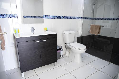 a bathroom with a toilet and a sink and a shower at Sun Hall Beach Hotel Apartments in Larnaka