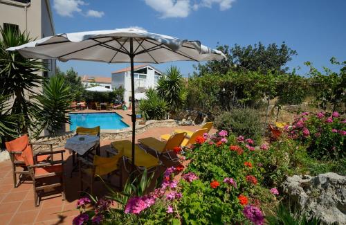 een groep stoelen en een parasol naast een zwembad bij Bicorna - Chania in Plaka