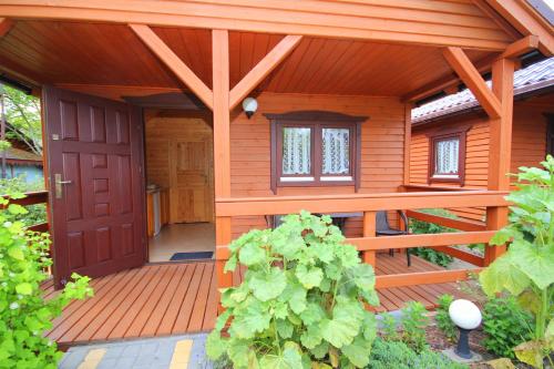 małą drewnianą kabinę z czerwonymi drzwiami w obiekcie Domki w Ogrodzie w Stegnie