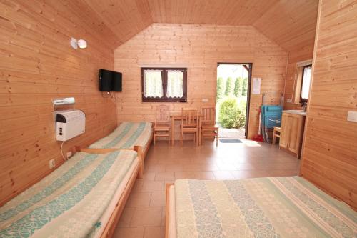 a room with two beds and a dining room at Domki w Ogrodzie in Stegna