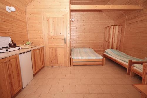 a room with a kitchen and a bunk bed at Domki w Ogrodzie in Stegna