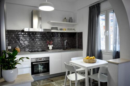 a kitchen with a white table and chairs and a table with a bowl of fruit at ISTRON BREEZE II in Istron