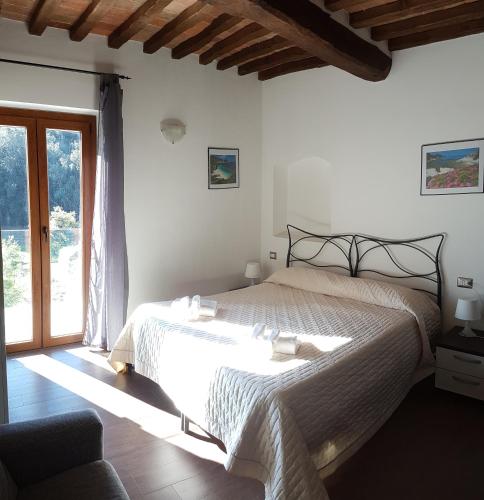 a bedroom with a bed and a large window at B&B Capo Pero in Rio Marina
