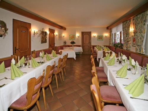 a restaurant with white tables and chairs with green napkins at Marias Pension in Falkenstein