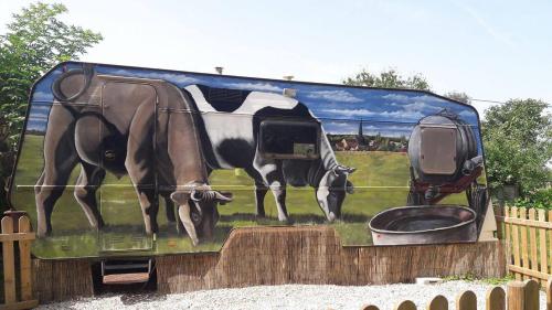 a painting of a cow on the side of a bus at ferme pedagogique des pennetieres in Montcorbon