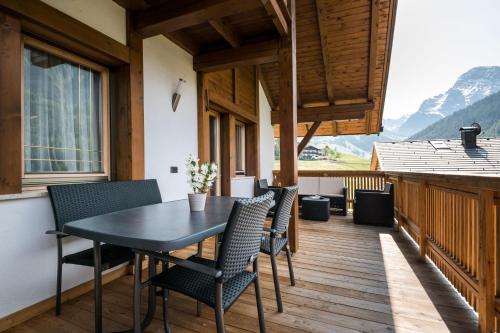 a balcony with a table and chairs on a deck at Apartments Tino in La Valle