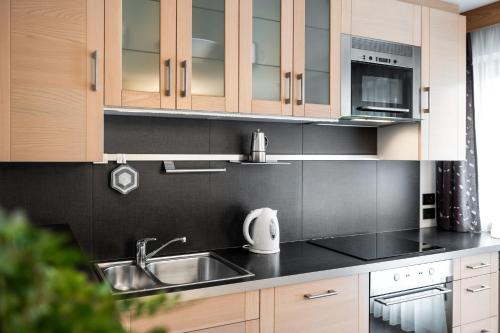 a kitchen with a sink and a microwave at Apartments Tino in La Valle