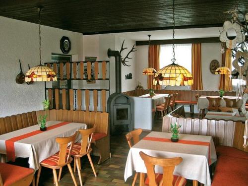 a restaurant with two tables and chairs and a stove at Marias Pension in Falkenstein