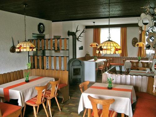 ein Restaurant mit 2 Tischen, Stühlen und einem Herd in der Unterkunft Marias Pension in Falkenstein