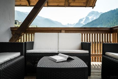 a balcony with two chairs and a table with a book on it at Apartments Tino in La Valle