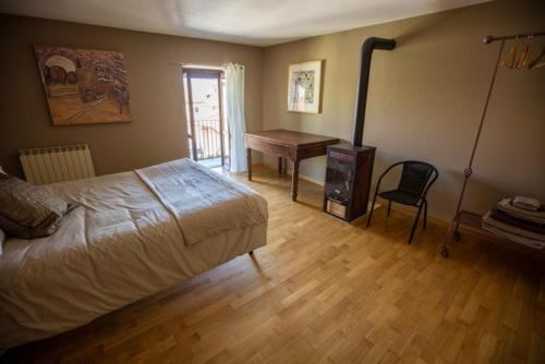 1 dormitorio con cama, mesa y escritorio en Casa Centro Storico, en Neive