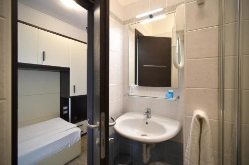 a small bathroom with a sink and a mirror at Hotel Bristol in Caorle