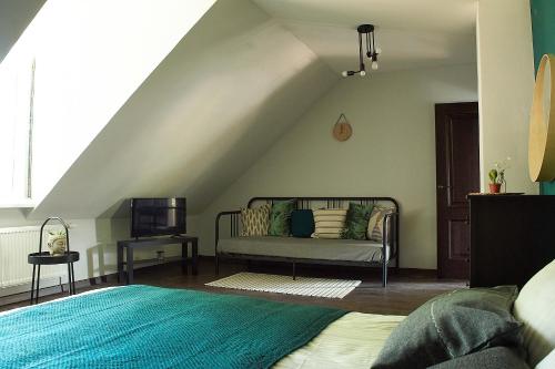 a bedroom with a couch and a tv in a attic at Greenhouse Apartments in Jūrmala
