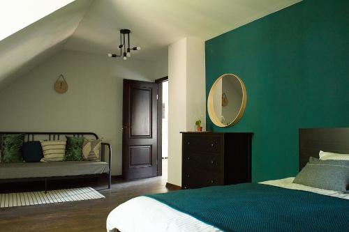a bedroom with a green wall with a bed and a mirror at Greenhouse Apartments in Jūrmala