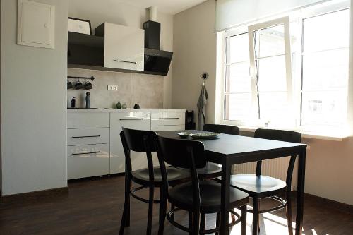 a kitchen with a table and chairs in a room at Greenhouse Apartments in Jūrmala