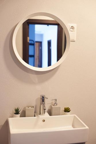 a bathroom with a white sink and a mirror at Greenhouse Apartments in Jūrmala