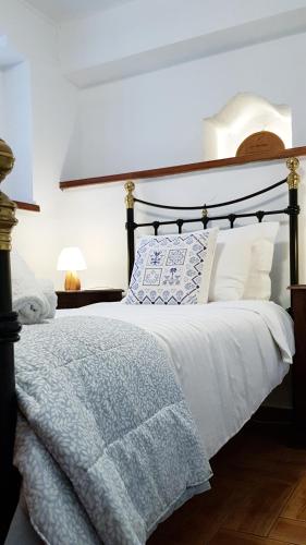 a bedroom with a bed with a blue and white blanket at Tsagarada Stone House 1898 in Tsagarada