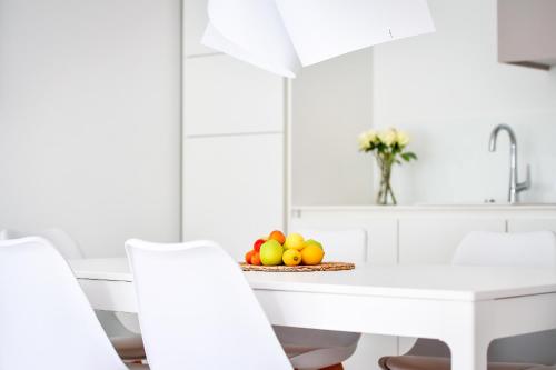 a white kitchen with a plate of fruit on a table at Oliver Lux in Tihany