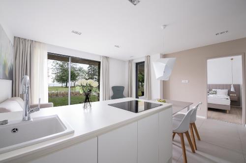a white kitchen with a sink and a counter at Oliver Lux in Tihany
