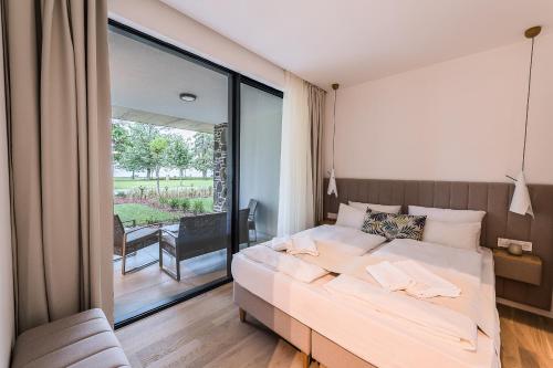 ein Schlafzimmer mit einem Bett und einem großen Fenster in der Unterkunft OliverLux Aparthotel in Tihany