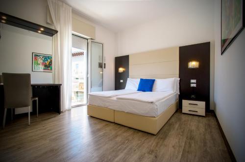a bedroom with a bed and a desk in it at Hotel Bristol in Caorle