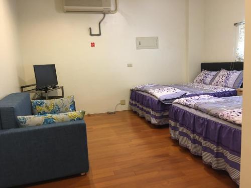 ein Wohnzimmer mit 2 Betten und einem Sofa in der Unterkunft Hong Guo Homestay in Ruisui