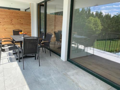 a patio with a table and chairs next to a sliding glass door at Villa Stiegl in Steindorf am Ossiacher See
