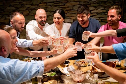 a group of people sitting around a table drinking wine glasses at Agrikea in Korissia