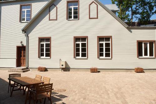 a house with a table and chairs in front of it at Greenhouse Apartments in Jūrmala