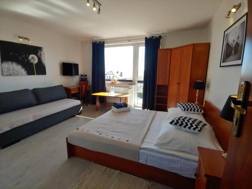 una camera da letto con un letto grande e un divano di Villa Plazowa 6 a Rewa
