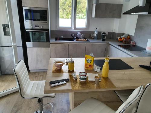 - une cuisine avec une table en bois et des boissons dans l'établissement Appartement Confortable, à Biguglia