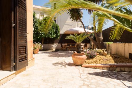 une terrasse avec une table, un parasol et des plantes dans l'établissement Maremosso, à Agrigente