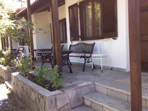 a patio with a bench and a table and chairs at Asprovalta Rooms in Kariotes