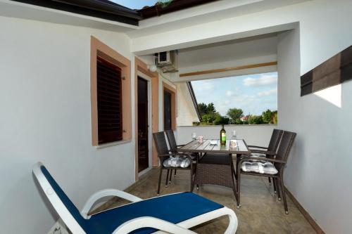 a balcony with a table and chairs and a window at Apartments Villa Elena in Poreč