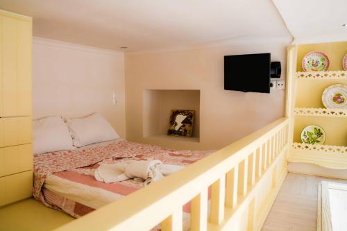 Un dormitorio con una cama y un televisor en la pared. en Kleio House, en Astipalea