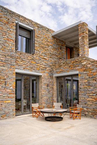 a patio with a table in front of a brick building at Agrikea in Korissia