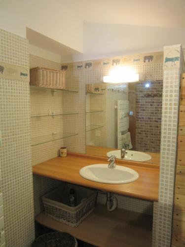a bathroom with two sinks and a mirror at Gîte Le Petit Nid in Portes