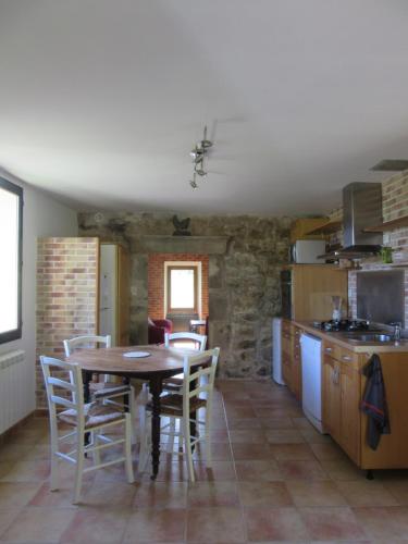 une cuisine avec une table et des chaises dans une pièce dans l'établissement Gîte Le Petit Nid, à Portes