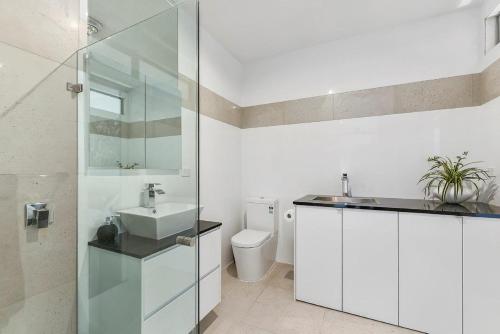 a white bathroom with a sink and a toilet at KENNEDY EXECUTIVE TOWNHOUSE in Mount Gambier