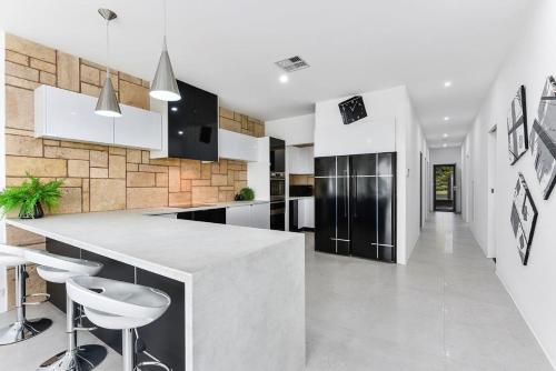 a kitchen with a counter and some stools at KENNEDY EXECUTIVE TOWNHOUSE in Mount Gambier