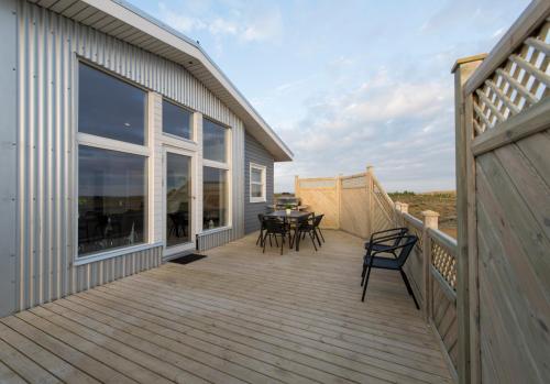 una gran terraza con mesa y sillas. en Icelandic Cottages en Hraunmörk